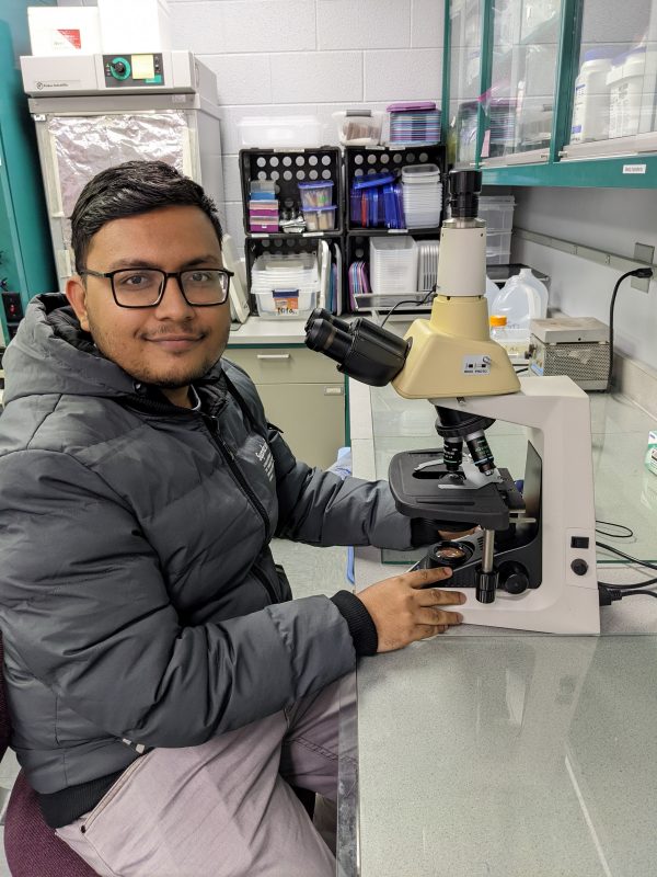 Mahadi in lab with microscope
