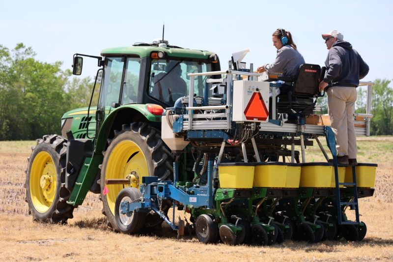 soybean research team planting in field using tractor
