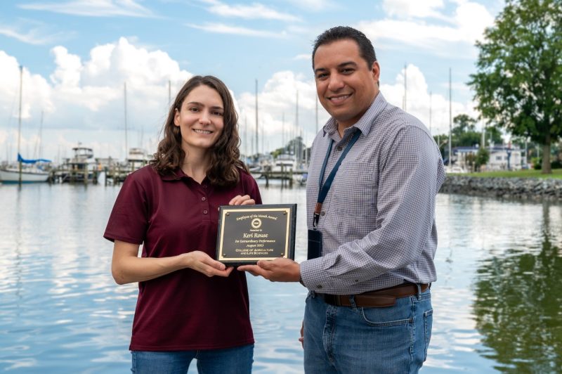 Keri Rouse accepting plaque from Jonathan van Senten on Hampton waterfront.