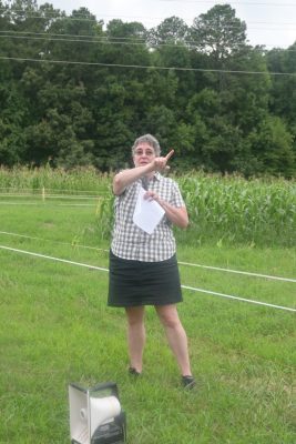 A professor in the field speaks to attendees at the field day.