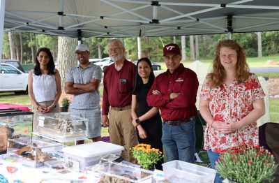 The entomology team stands behind their booth at the Family & Farm Day event.