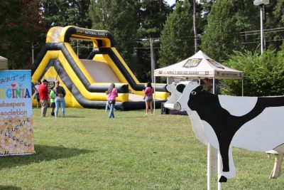 A cow display stands in front of the children's slide at Family & Farm Day,