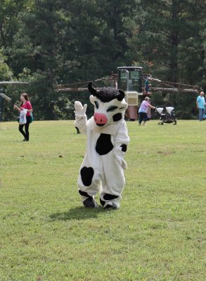 A person dressed as a cow greets Family & Farm Day visitors.