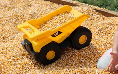 A toy dump truck loaded with corn kernels at child's play area during Farmily & Farm Day.