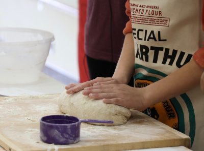 Child kneading dough for bread.