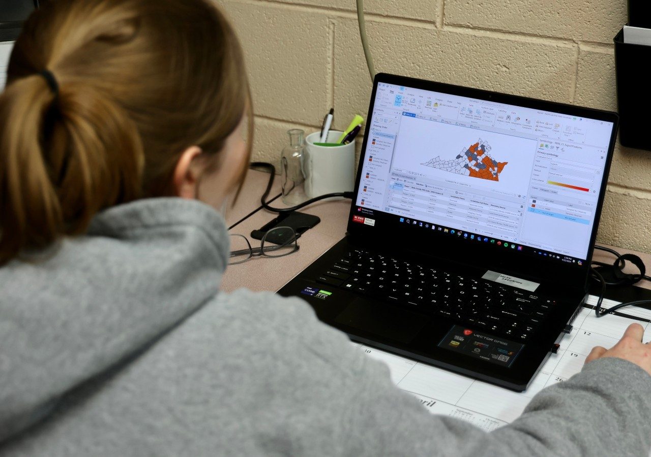 Lab technician uses laptop to map nematode populations across Virginia counties