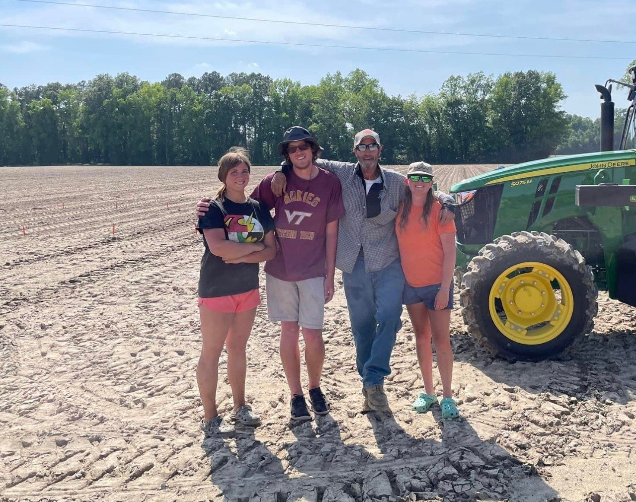 Four researchers in field with tractor